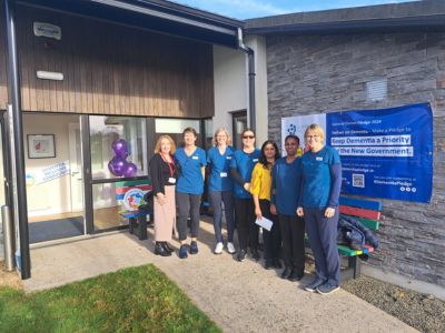 7 healthcare workers standing outside the door of a healthcare building.