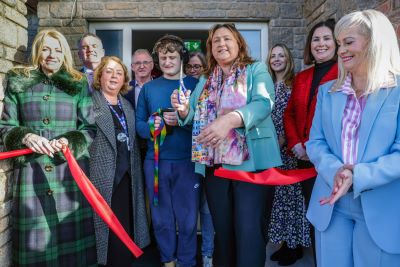 Large group of people standing outside for a ribbon cutting at Rainbow Lodge Children’s Respite Centre.