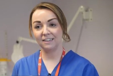 Orla Mongan, Advanced Midwife Practitioner wearing a blue tunic and looking straight ahead.