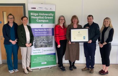 A group of of members of Sligo University Hospital being awarded their An Taisce Green Flag.  A pull-up banner reads:  Sligo University Hospital Green Campus
