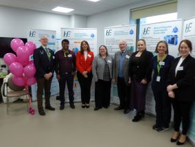 Large group of people standing in arow beside some pink balloons and in front of  HSE pull up banners