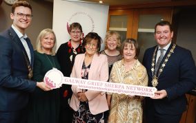 Group of people pictured with the Mayor of Galway city at the launch of New Bereavement Support Initiative in Galway. They are holding a sign that reads, Galway Grief Sherpa Network. 